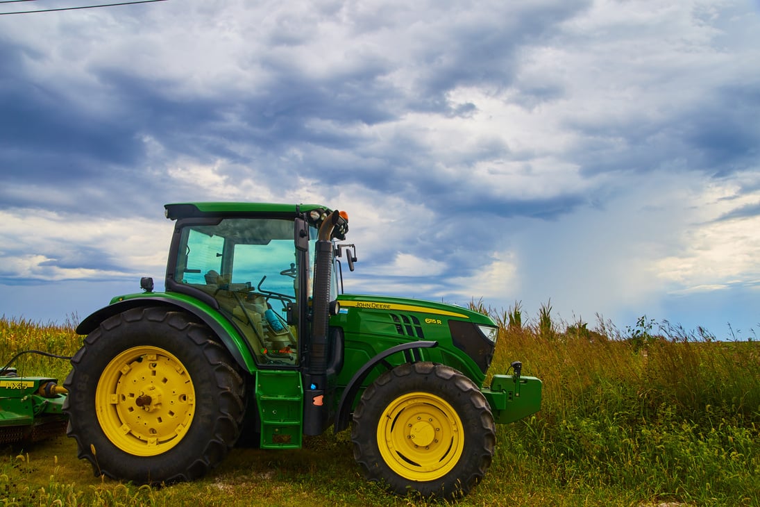 Farming Tractor Equipment John Deer with Stormy Clouds